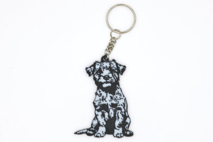 Keychain with a black and white Border Terrier silhouette dog design on a white background